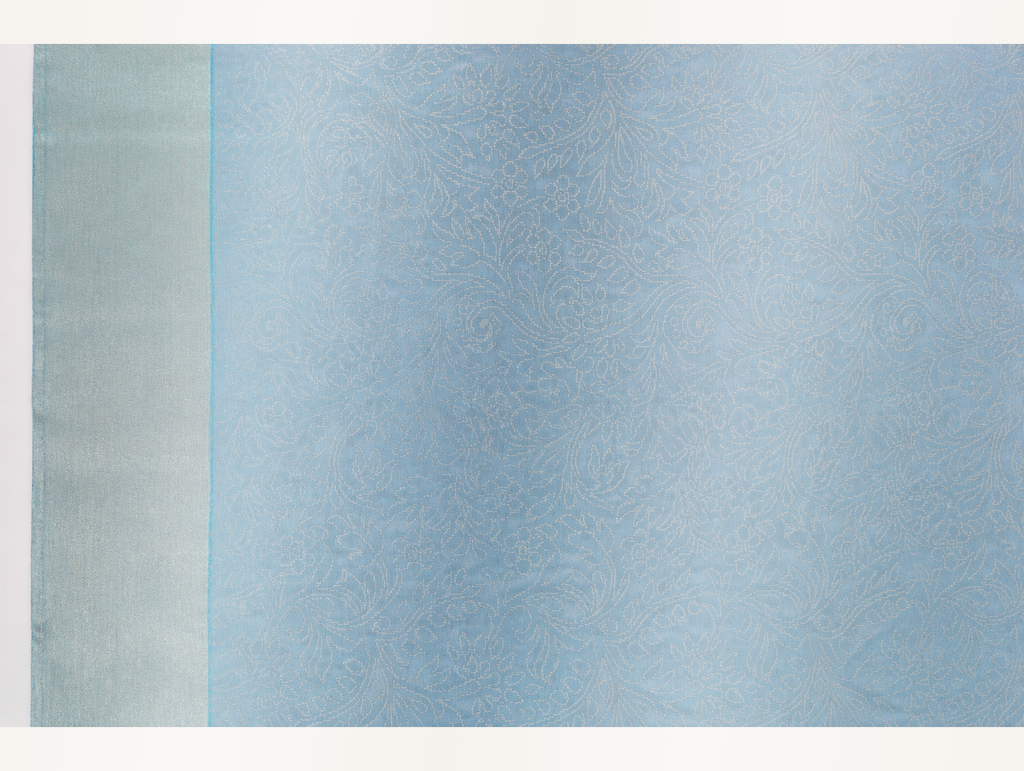 Close view of the ice blue saree body with dense tonal floral paisley jacquard and pale silver border