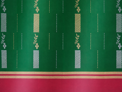 Close detail of the Vanya emerald-green body with alternating gold- and silver-tone woven motifs and a dusty-rose border.